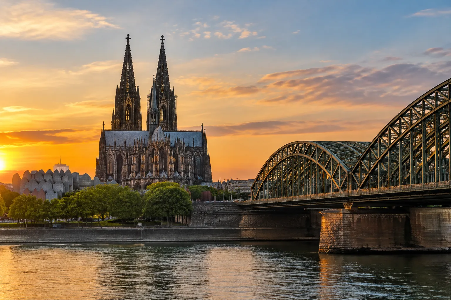 Kölner Dom über dem Rhein mit der Hohenzollernbrücke im Abendlicht